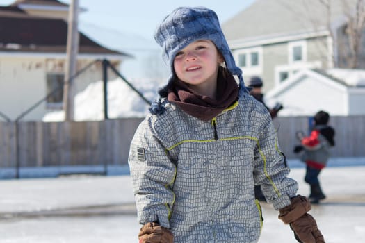Little girl skating at an outdoor skating rink.