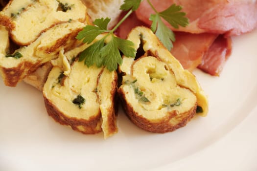 Delicious sliced rolled omelette with bacon and Turkish bread with parsley.