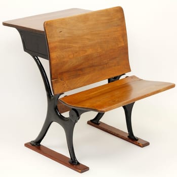 One vintage metal and wood school desk and school chair combination with a desk in back and a chair in the front.