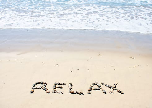 Relax written in sand at beach