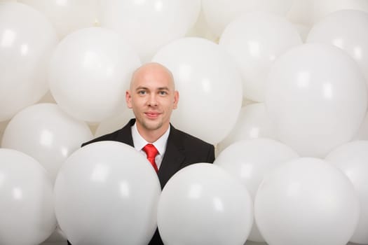Man surrounded by balloons at corporative party