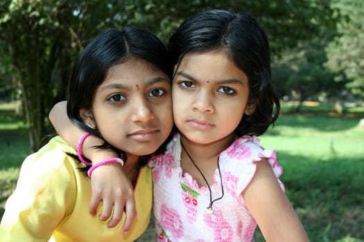 Younger sister affectionately putting her arm over the shoulder of her elder sister
