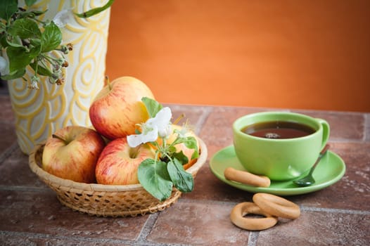 Beautiful ripe apples and branches of a blossoming apple-tree in a vase