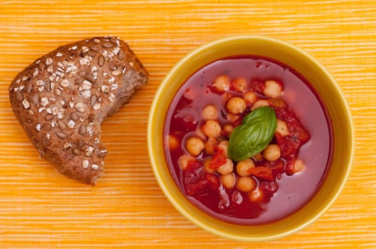 Wholemeal rolls with a bowl of red soup with tomatoes and chickpeas