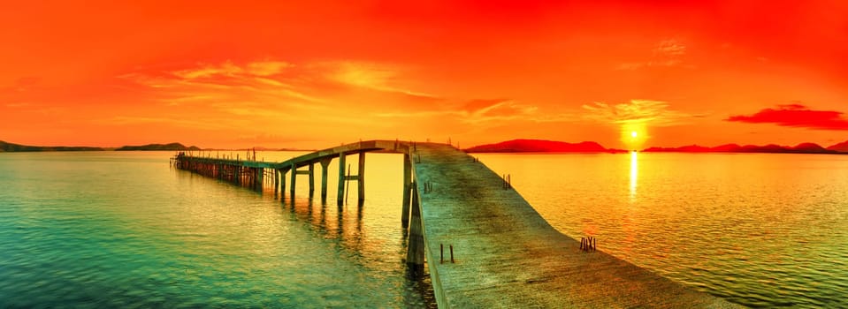 Sunset over the sea. Pier on the foreground. Panorama