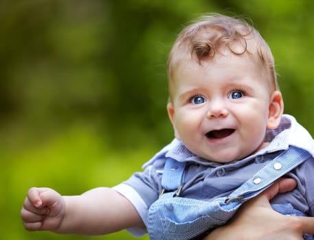 Portrait of a happy baby boy portrait outdoor in summer.
