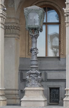 Vintage lamppost in front of a dilapidated old house with a window