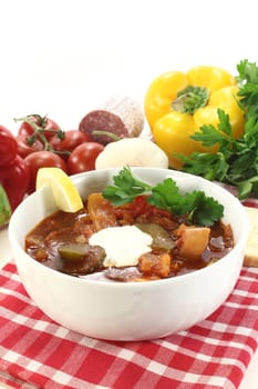 a bowl of solyanka with cream and lemon