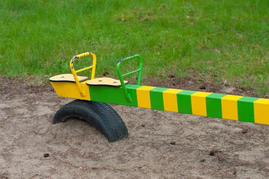 detail of a green with yellow see saw