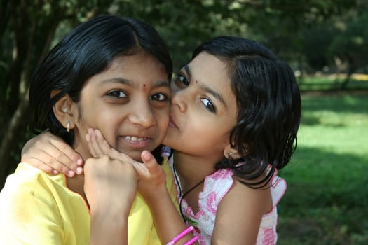 Younger sister affectionately kissing her elder sister