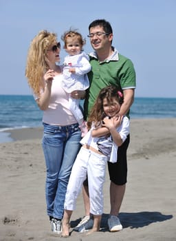 happy young family have fun and live healthy lifestyle on beach
