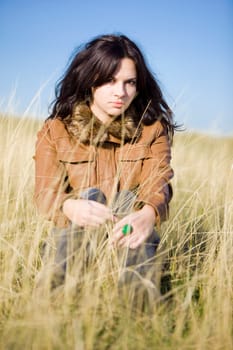young beautiful woman in the nature with the grass and the sky as a background