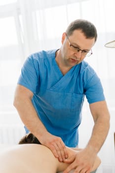 Young fat woman getting massage treatment in a day spa cabinet.