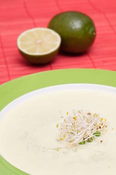 Cream of vegetable soup with alfalfa sprouts and limes