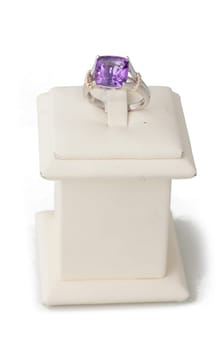 Ring with purple stone on display stand