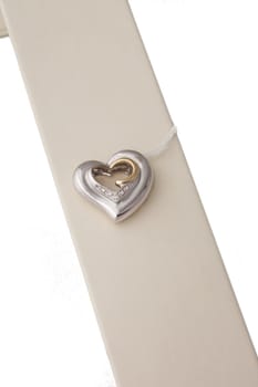 Silver and gold heart pendant on display stand