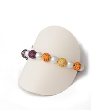 Multicolored ball and pearl bracelet on display stand