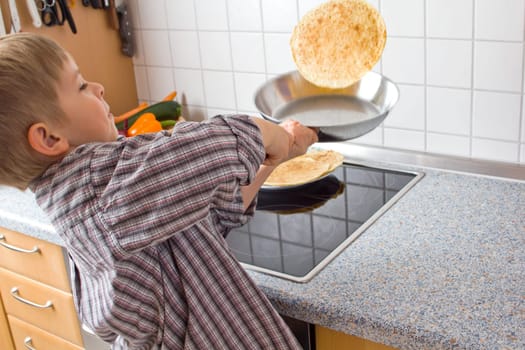 Young 5 years old baking pancakes