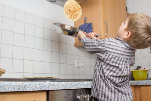 Young 5 years old baking pancakes