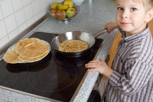 Young 5 years old baking pancakes