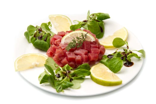tuna tartare with fresh salad and lemon slice