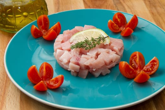 swordfish tartar with fresh salad and lemon slice