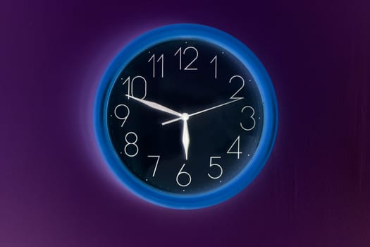 Shaded clock hanging on wall and showing time