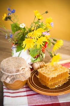 Still life with honeycombs, flowers and pot