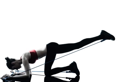 one caucasian woman exercising elastic gymstick in silhouette studio isolated on white background