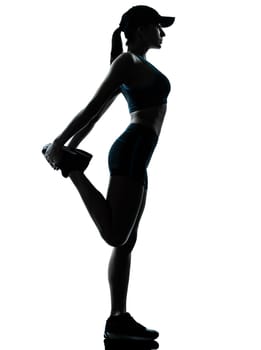 one caucasian woman runner jogger stretching legs in silhouette studio isolated on white background