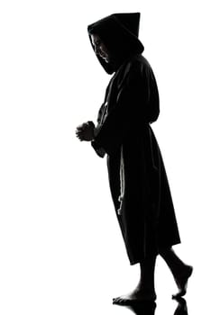one caucasian man priest praying silhouette in studio isolated on white background