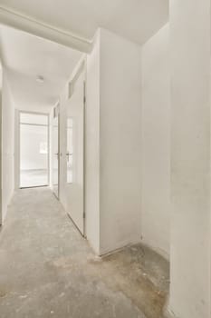 an empty room with white walls and no one person standing in the doorway to the right, looking at the door