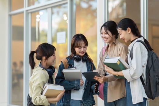 university students using a digital tablet while walking to next class.