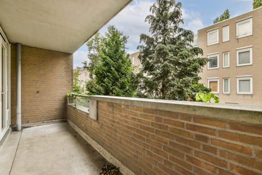 a brick wall with trees in the background and bushes growing on the side of the building, as seen from outside