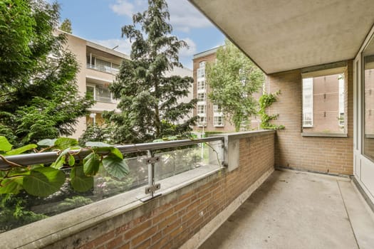 an outside area with trees and buildings in the background, taken from a balcony looking out to the street below