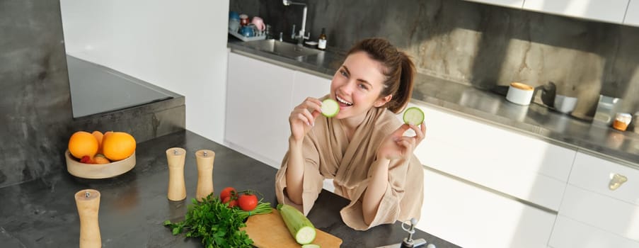 Portrait of good-looking woman cooking salad in the kitchen, chopping vegetables and smiling, preparing healthy meal, leading healthy lifestyle and eating raw food.