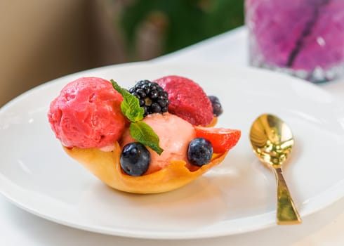 Berry sorbet with three flavors - strawberry, raspberry, black currant. Scoop ice cream sorbet decorated fresh berries and mint. Summer ice cream concept