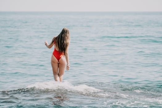 Woman sea yoga. Back view of free calm happy satisfied woman with long hair standing on top rock with yoga position against of sky by the sea. Healthy lifestyle outdoors in nature, fitness concept.