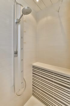 a bathroom with white tiles on the walls and shower head mounted to the wall in front of the bathtub