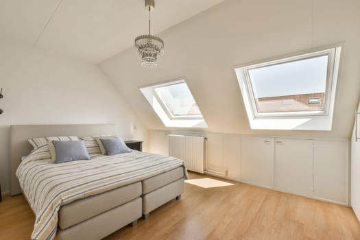 a bed in a room with skylights on the roof and wood flooring around it, as well as possible