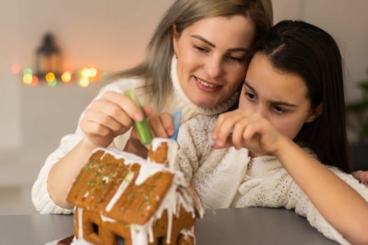 Family decorating gingerbread house on Christmas eve.