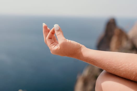 Middle aged well looking woman with black hair doing Pilates with the ring on the yoga mat near the sea on the pebble beach. Female fitness yoga concept. Healthy lifestyle, harmony and meditation.