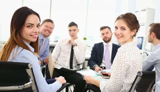 Portrait of smart colleagues discussing important biz topic that can determine corporation future. Smiling manager looking at camera with joy. Company meeting concept