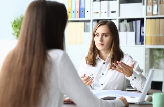 Portrait of smart businesspeople sitting in modern workplace and talking about tactics and profits in paper tablet with significant charts. Accounting office concept