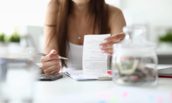Focus on tender hands of businesswoman sitting indoors with metallic silver pen and important tablet with significant business documents. Office concept. Blurred background