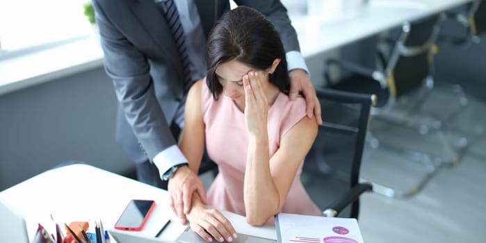 Businessman pestering female colleague in the workplace. Harassment at work concept