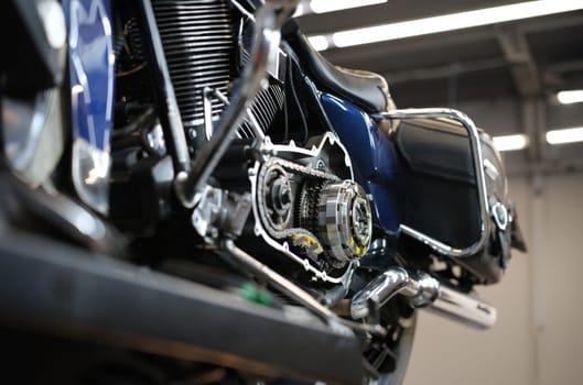 Open chromed motorcycle motor with chain on bench in garage. Engine diagnostics concept