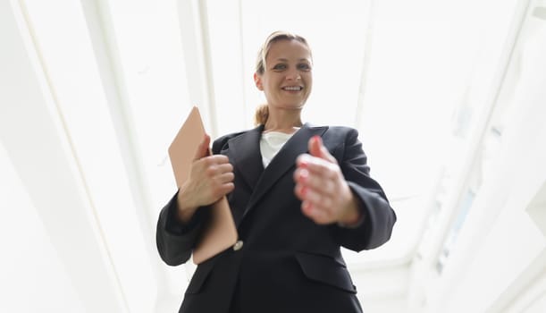 Young woman in business suit stretching out her hand for handshake bottom view. Successful business deal concept
