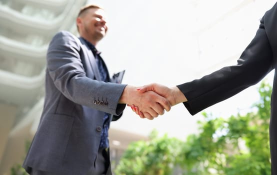 Business man and woman in suits shaking hands closeup. Business negotiations concept