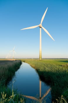 windturbine reflected in a ditch in early morning